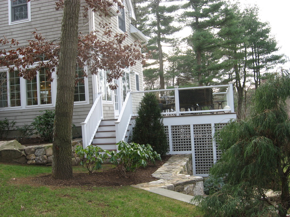 The stonework, lattice, and glass railings add to the ambiance of this large deck.